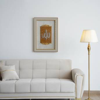White sofa in a room with a framed picture and a lamp.