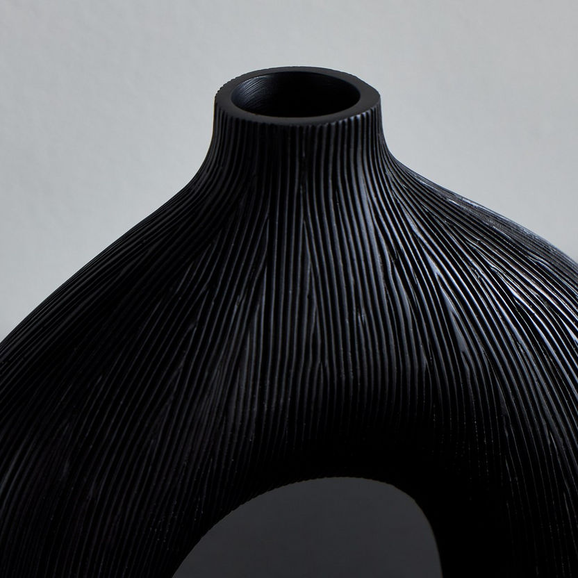 Black textured vase on a gray background