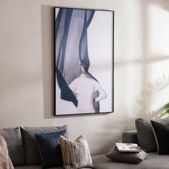 Framed artwork on a wall above a sofa with cushions