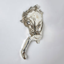 Silver horse head sculpture on a light gray background