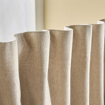 Close-up of beige fabric panels against a white and beige wall.