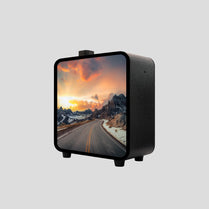 A black square-shaped diffuser machine with a picture of a road leading towards mountains at sunset.