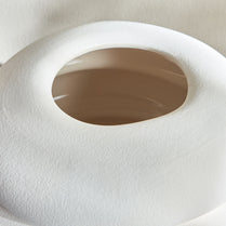 Close-up of a white toilet seat with a brown rim on a beige background