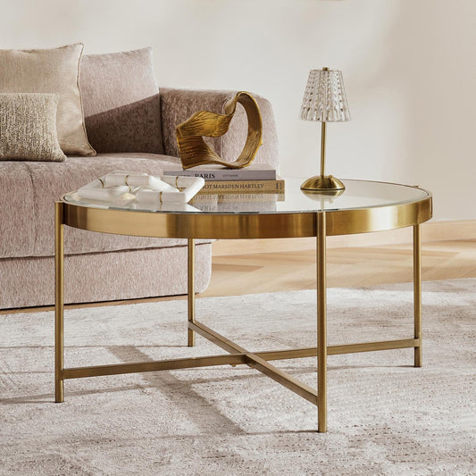 Gold coffee table with a lamp and books in a living room setting