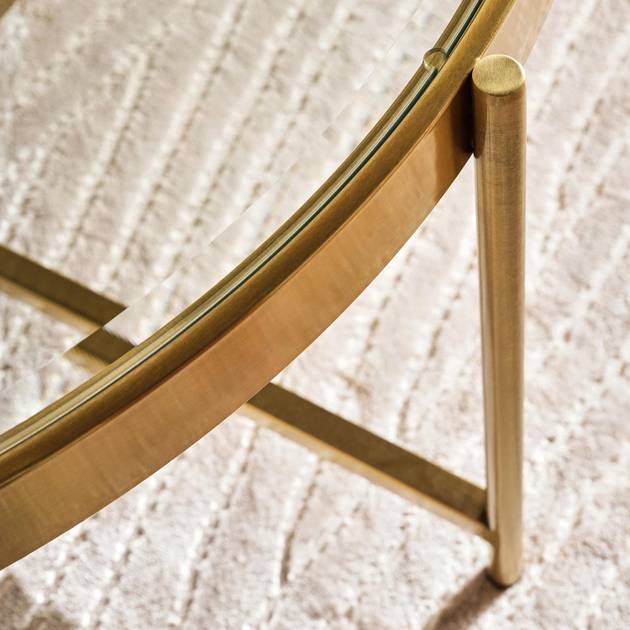 Close-up of a gold-framed mirror on a textured white wall