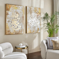 Two abstract art pieces on a wall in a living room with a couch and plant.