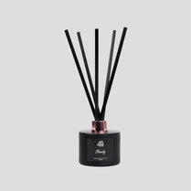Black diffuser with sticks on a light gray background