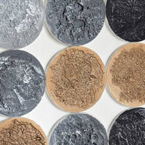 Close-up of round stone tiles in various colors on a white background