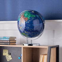 Globe on a stand against a blue wall with books stacked below- Vasco Globe Table Lamp_ 40cm LED USB Powered