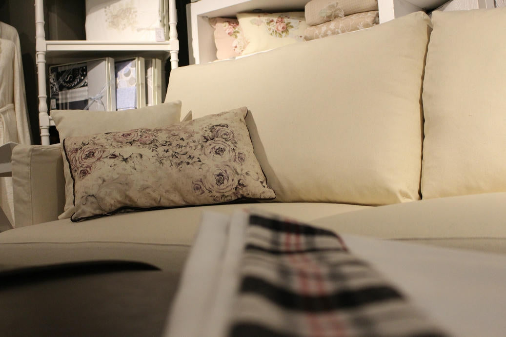 Beige sofa with decorative pillows and a striped blanket in a home setting. Vienna Collection Sofa – Where Sophistication Meets Comfort | Vella Concept