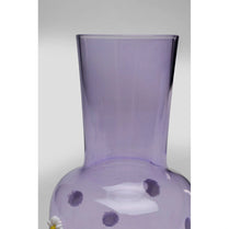 Purple glass vase with white flowers on a light gray background