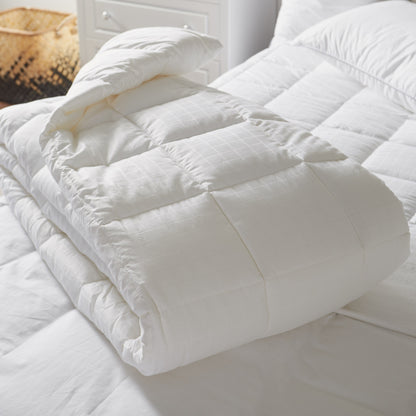 White quilted comforter on a bed with pillows
