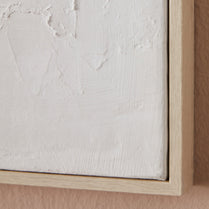 Close-up of a textured white canvas with a wooden frame on a beige background