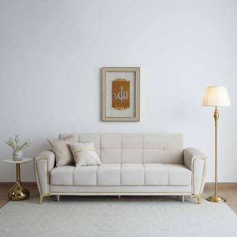Beige sofa in a living room with a lamp, side table, and wall art.