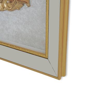 Close-up of a gold-framed mirror with intricate detailing on a white background