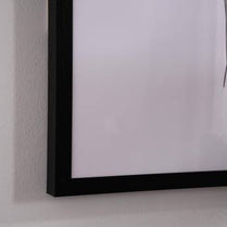 Black framed mirror on a white wall