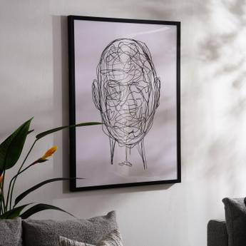 Framed abstract art of a face on a wall in a living room setting