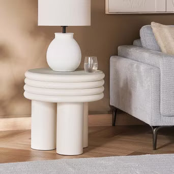 Modern side table with a lamp and glasses in a living room setting