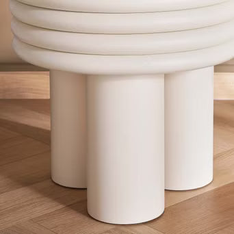White cylindrical stool on a wooden floor