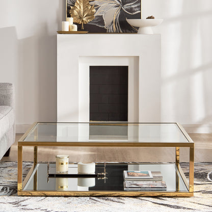 Gold and glass coffee table in a living room setting with a fireplace.