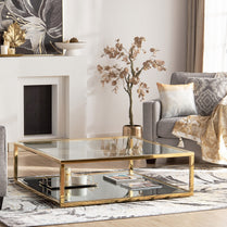 Modern living room with a gold coffee table, gray sofa, and decorative elements.