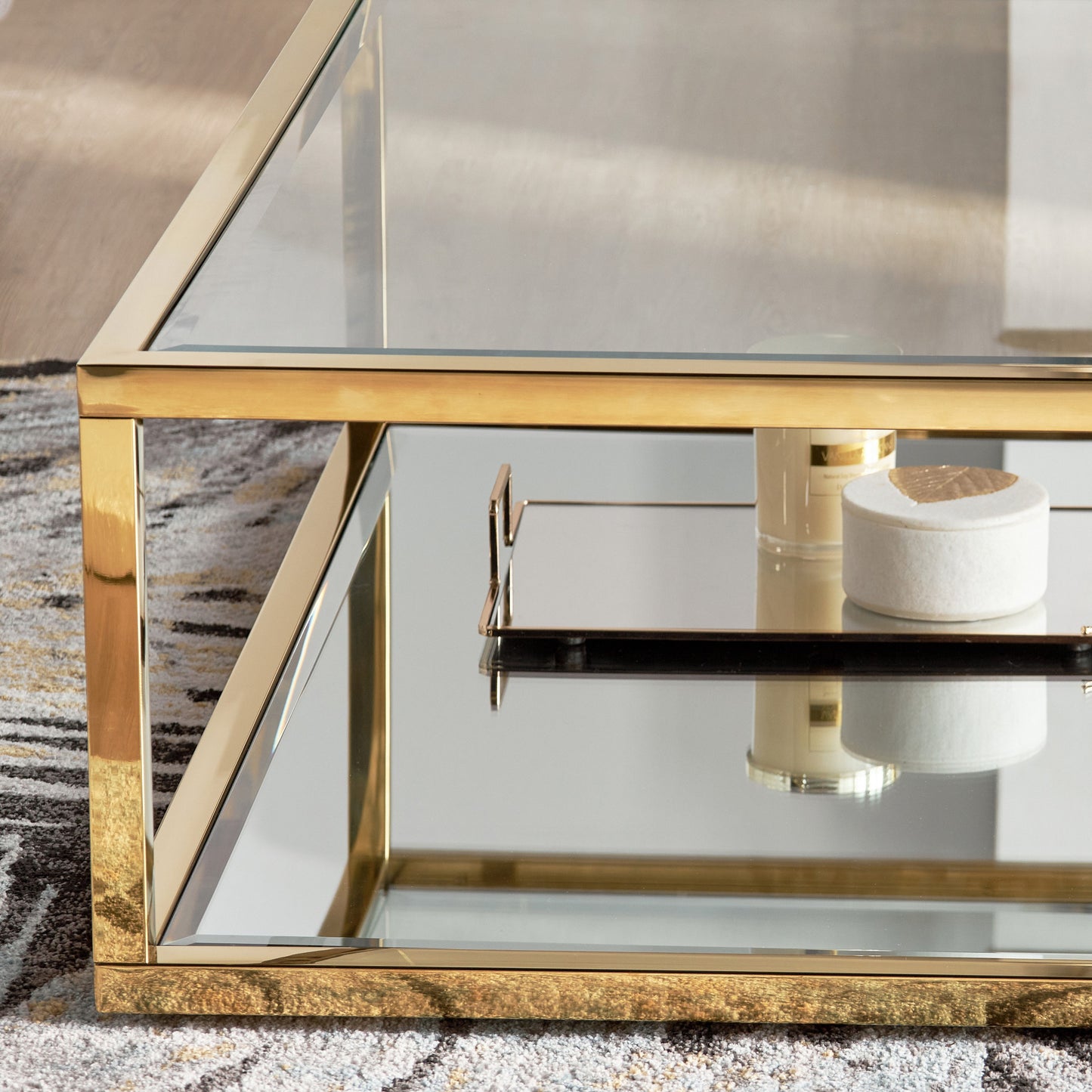 Gold-framed glass coffee table with a reflective surface