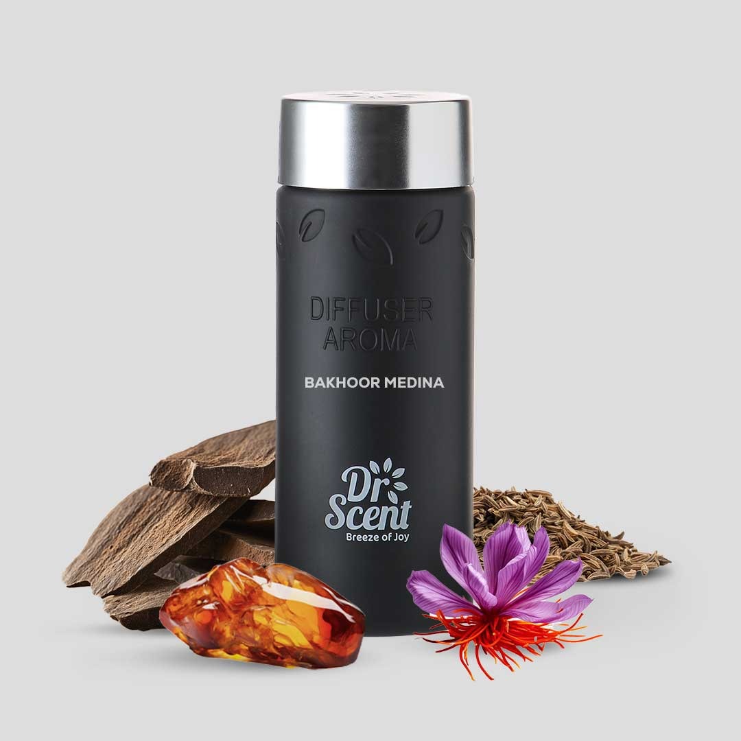 Black diffuser with silver top, surrounded by natural elements on a light gray background