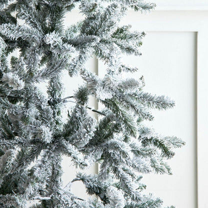 Frosted Christmas tree with a white candle against a white background