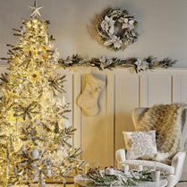 Decorated Christmas tree with lights in a living room setting.