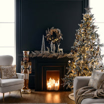 Decorated Christmas tree and fireplace in a living room with festive decorations.