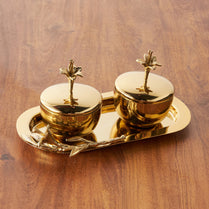 Gold decorative items with palm tree designs on a wooden surface