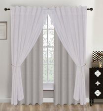 White curtains with a subtle pattern hanging in front of a window.