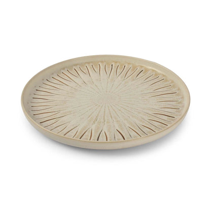 Round ceramic plate with radial design on a white background