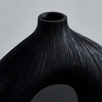 Black textured vase on a gray background