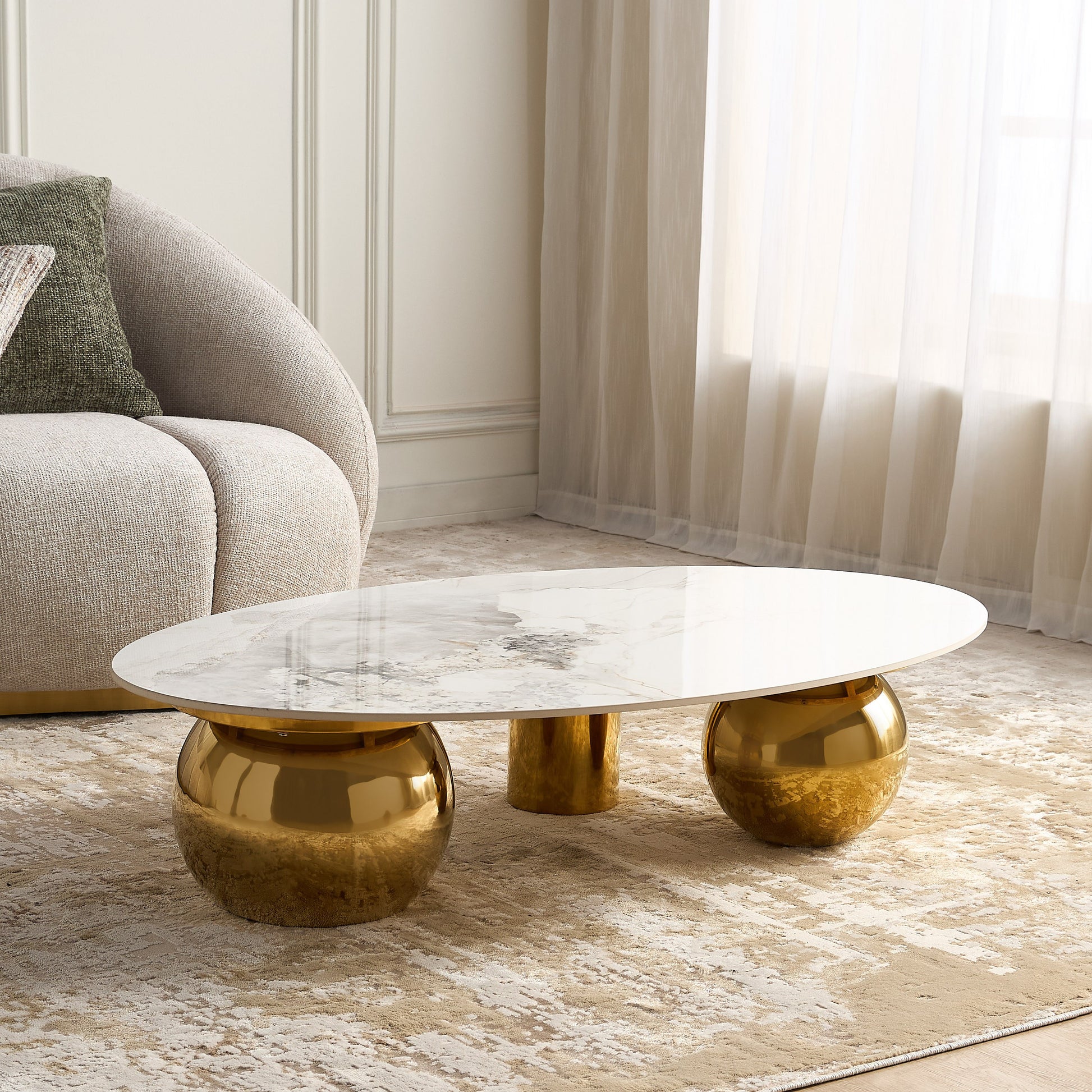 Modern coffee table with gold base and marble top in a living room setting