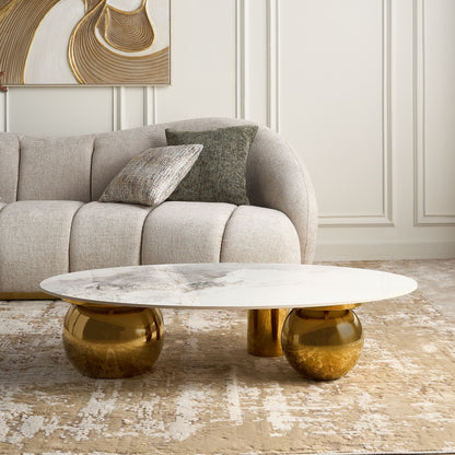 Modern coffee table with gold base and marble top in a living room setting.