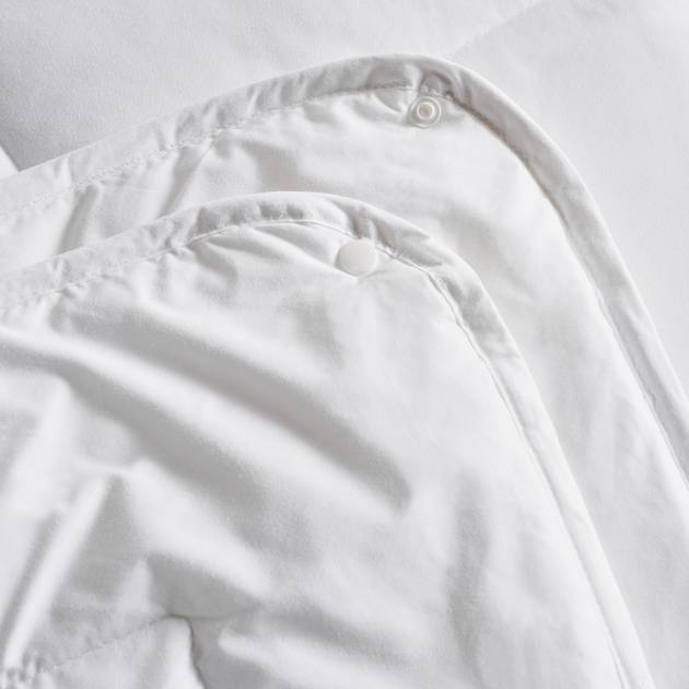 Close-up of a white shirt with buttons on a light gray background