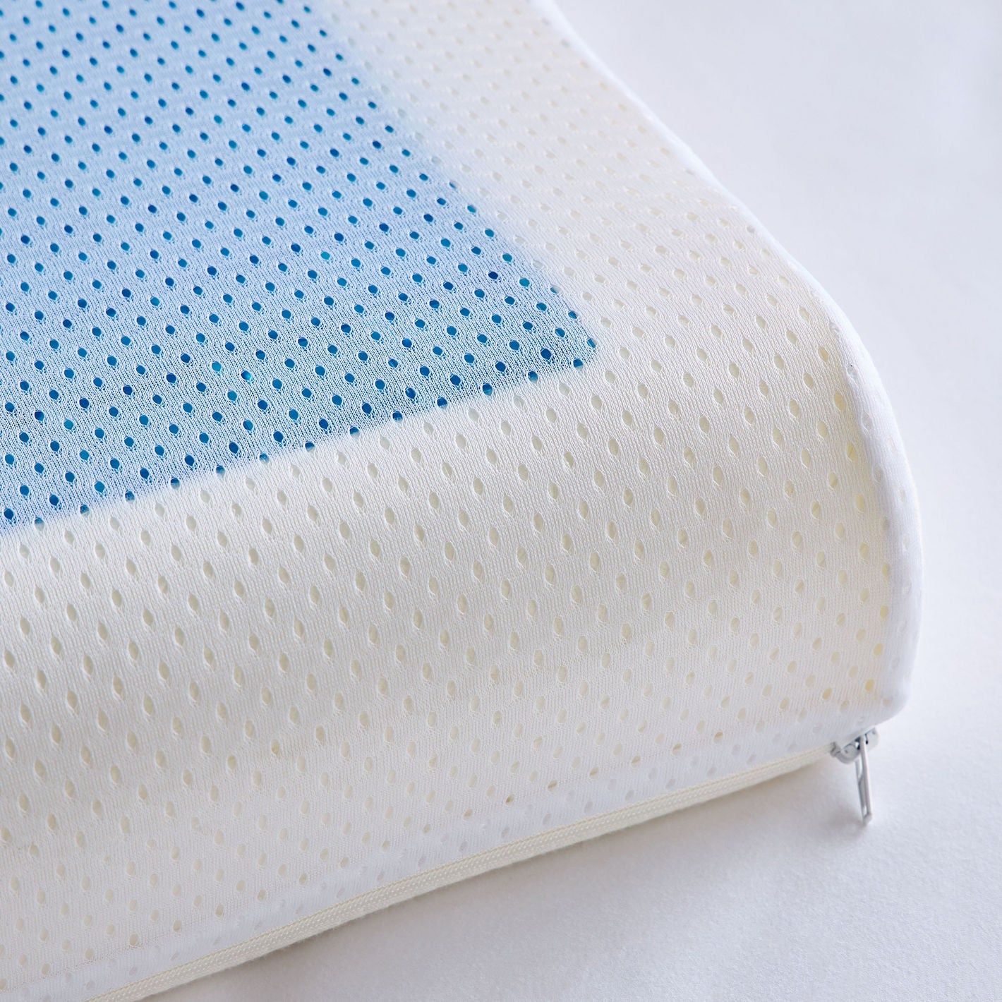 Close-up of a white and blue textured pillow on a light gray background