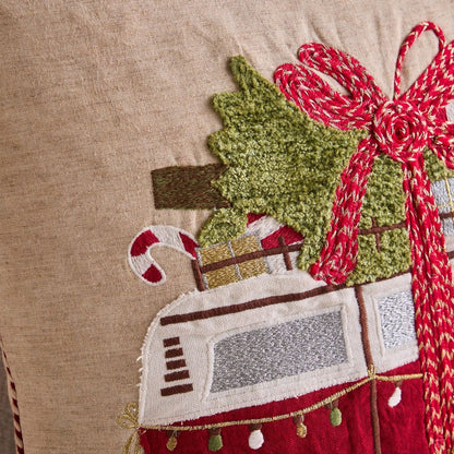 Decorative pillow with a Christmas scene featuring a truck, tree, and Santa.