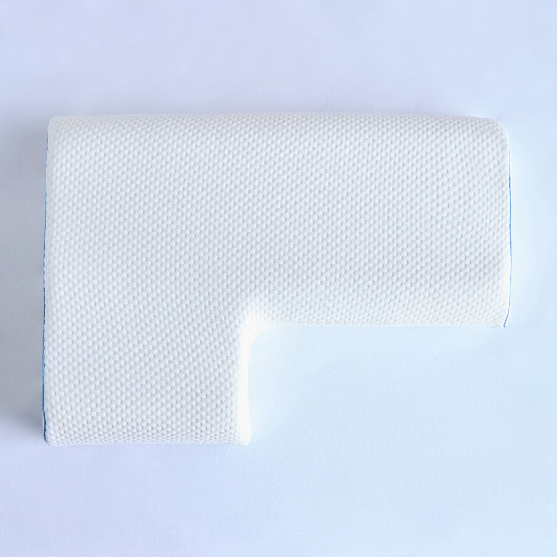 White pillow with textured surface on a light blue background