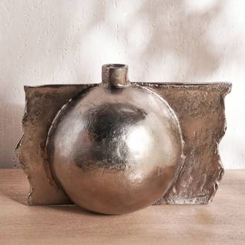 Metallic vase with spherical design on a wooden surface