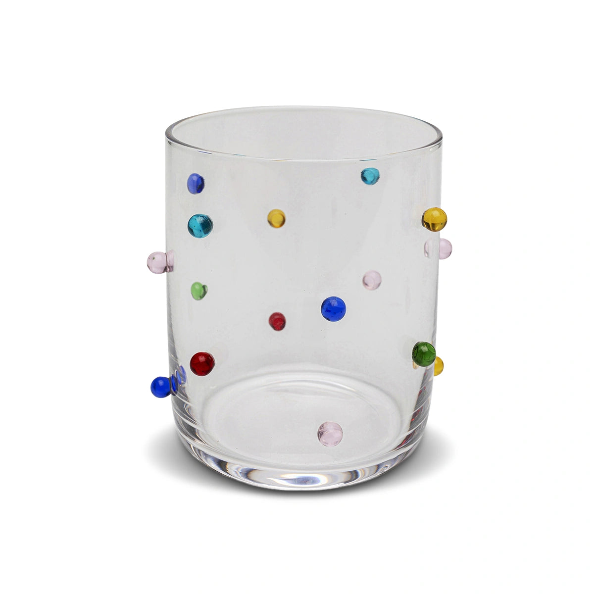 Clear glass tumbler with multicolored dots on a white background