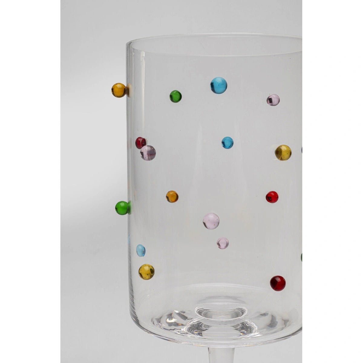 Clear glass with multicolored dots on a white background