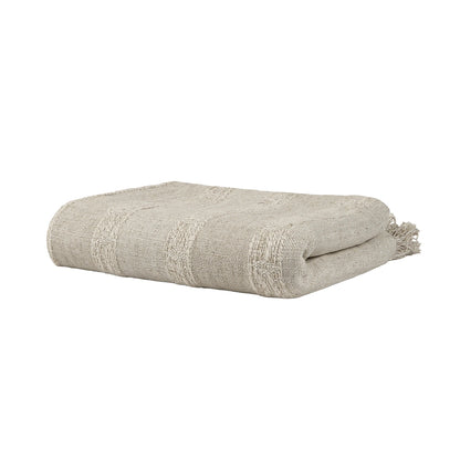 Folded beige blanket with tassels on a white background