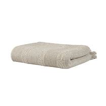 Folded beige blanket with tassels on a white background