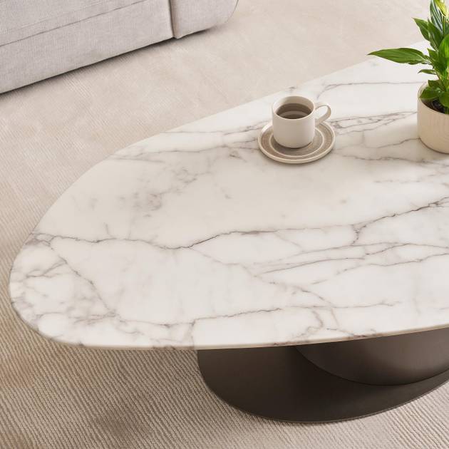 Marble-patterned coffee table with a cup and plant in a living room setting