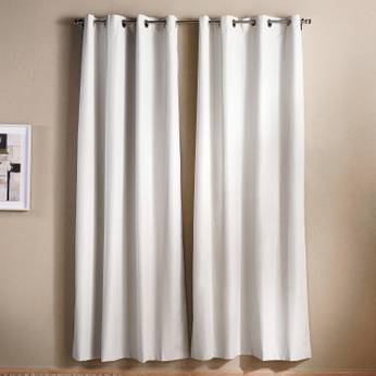 White curtains hanging against a beige wall with a framed picture.