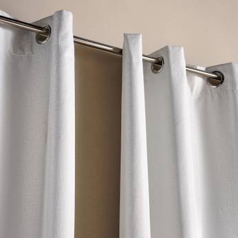 White curtains with gold rings on a beige background