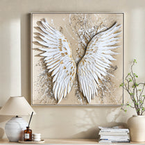 Abstract painting of white wings on a beige background in a home setting.