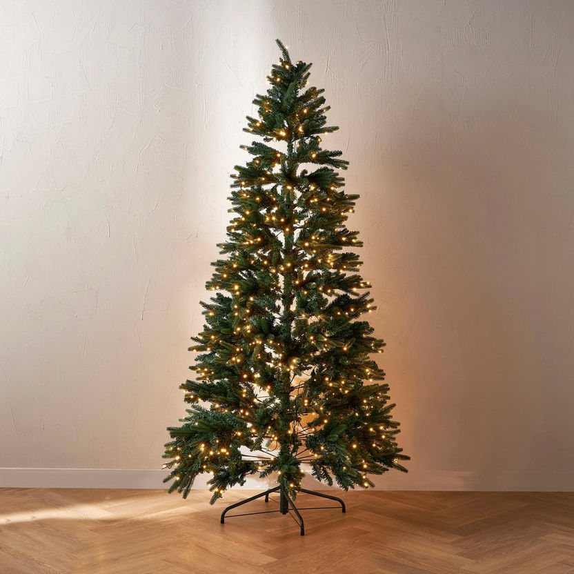 Decorated Christmas tree with lights on a plain background